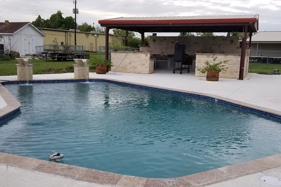 A beautiful remodeled swimming pool and outdoor barbeque area.