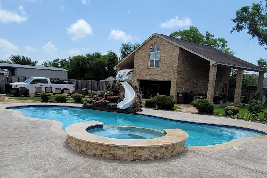 A beautiful remodeled swimming pool and swimming pool slide.