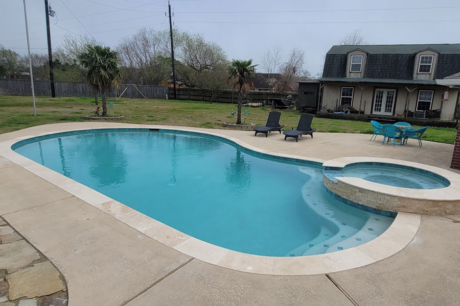 A large swimming pool in a grand backyard.